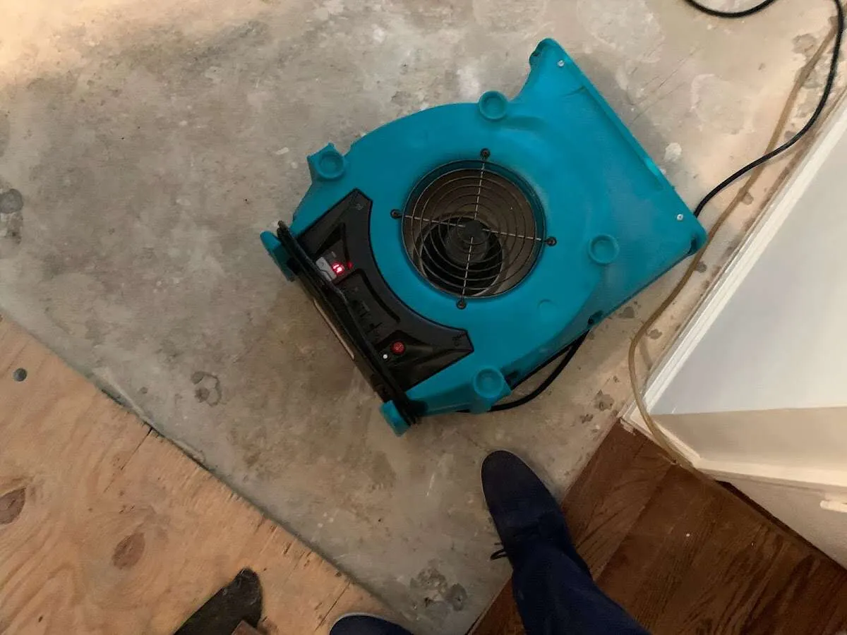 Air mover drying subfloor during Commercial Water Damage Restoration in Burton